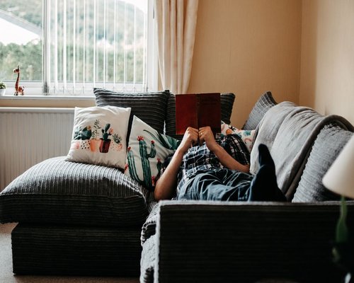 person reading a book in a comfortable room
